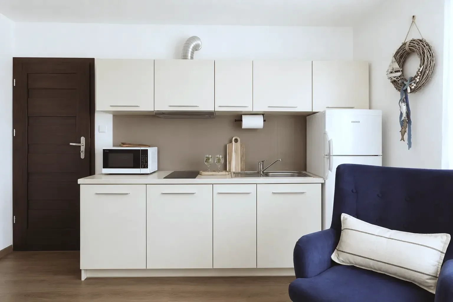Apartament SolMare Karwia - aneks kuchenny i granatowy fotel